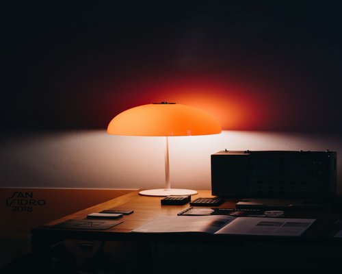 A vintage desk lamp casting warm light on papers
